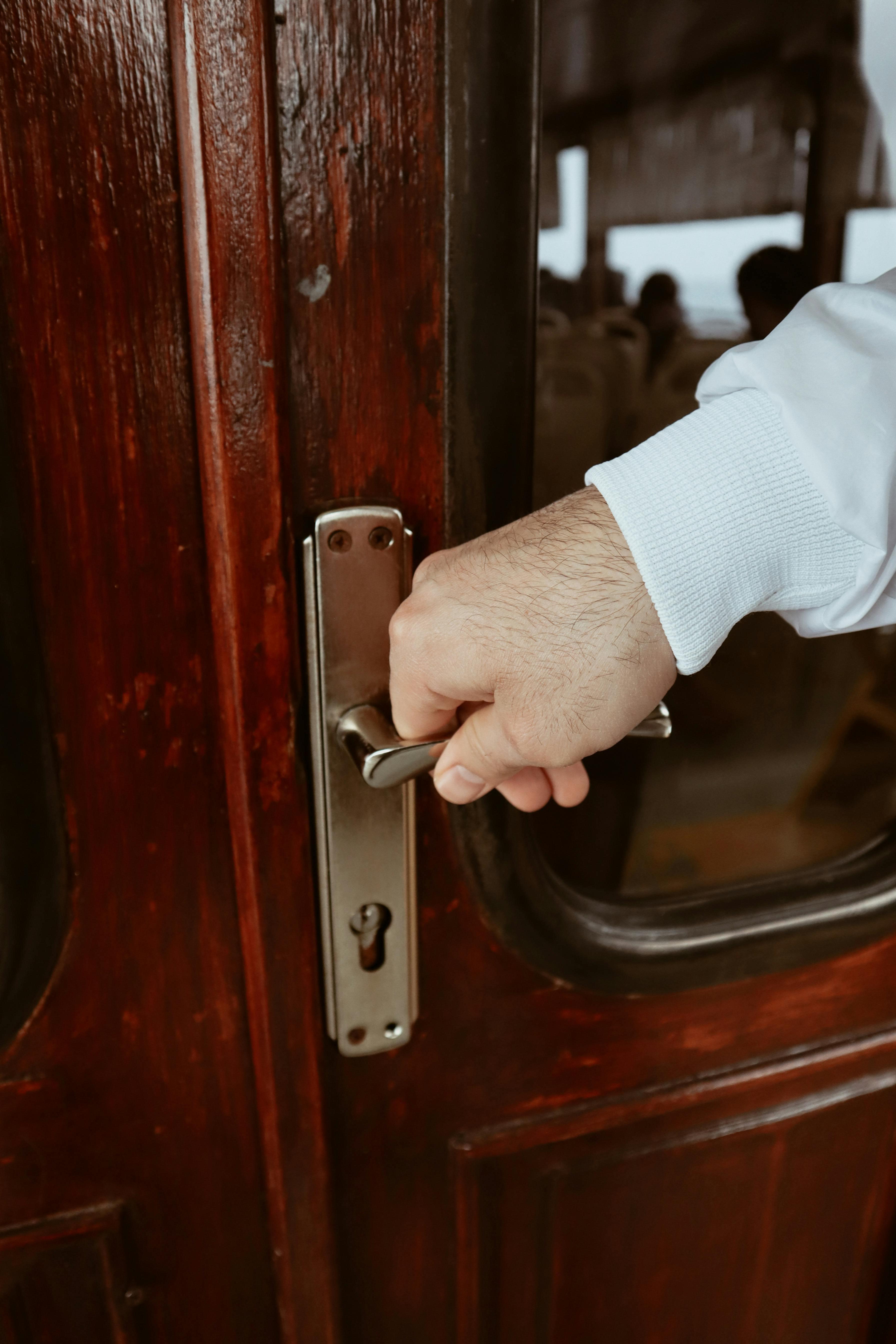 A person grabbing a door handle | Source: Pexels