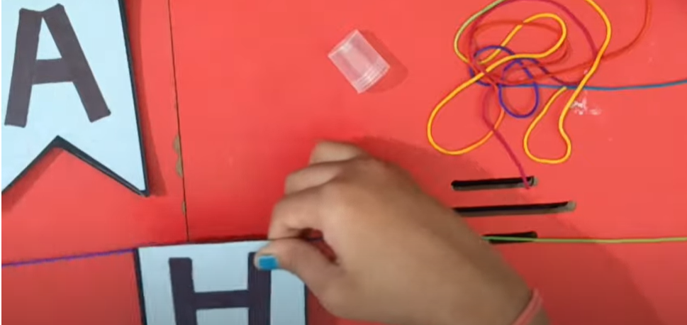 A  person attaching pieces of paper using a string | Source: YouTube/@hinalscreation1310