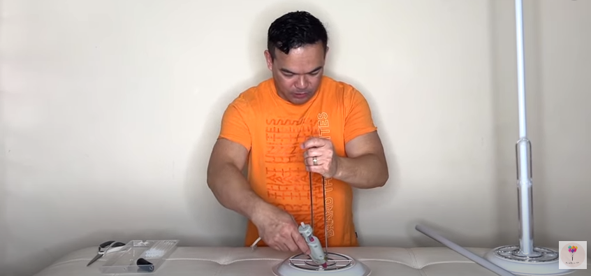 A person holding a glue gun and a paper towel holder | Source: YouTube/fambamny/videos