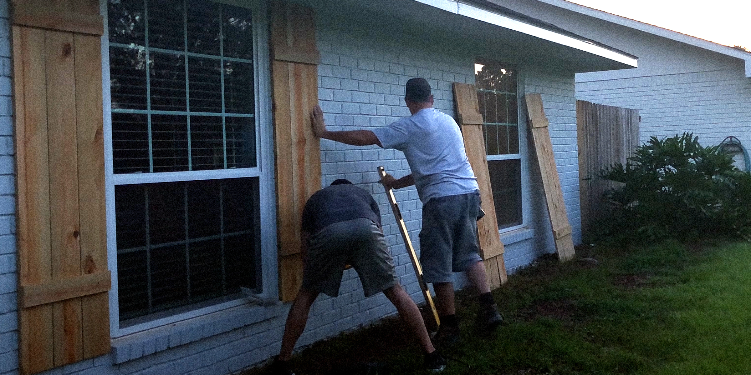 Men installing DIY hurricane shutters | Source: YouTube/StudPack