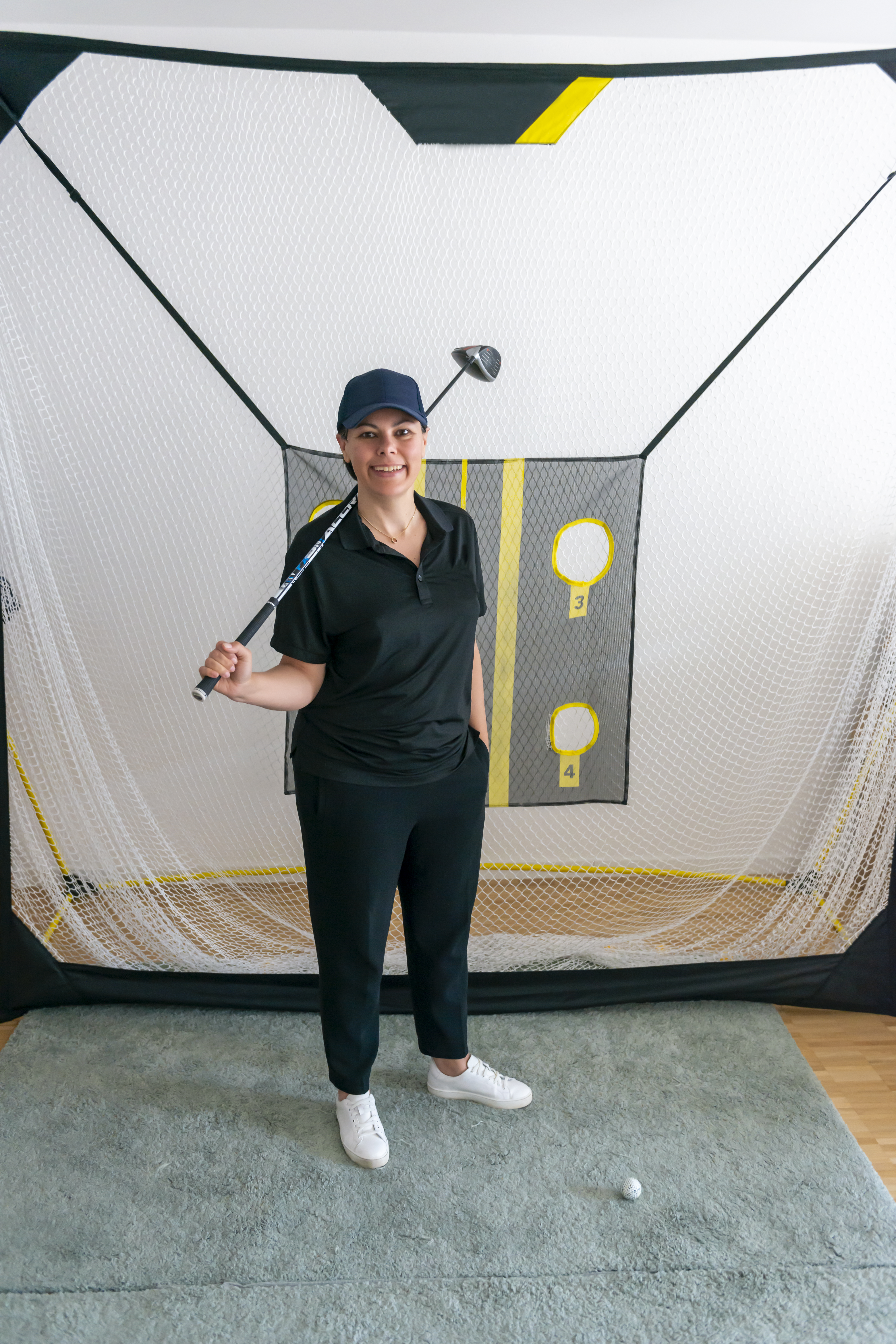 A golfer standing by her indoor golfing net | Source: Getty Images