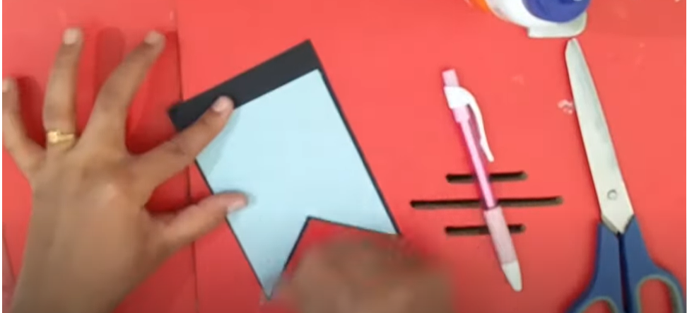 A person gluing a piece of white paper onto a black one | Source: YouTube/@hinalscreation1310
