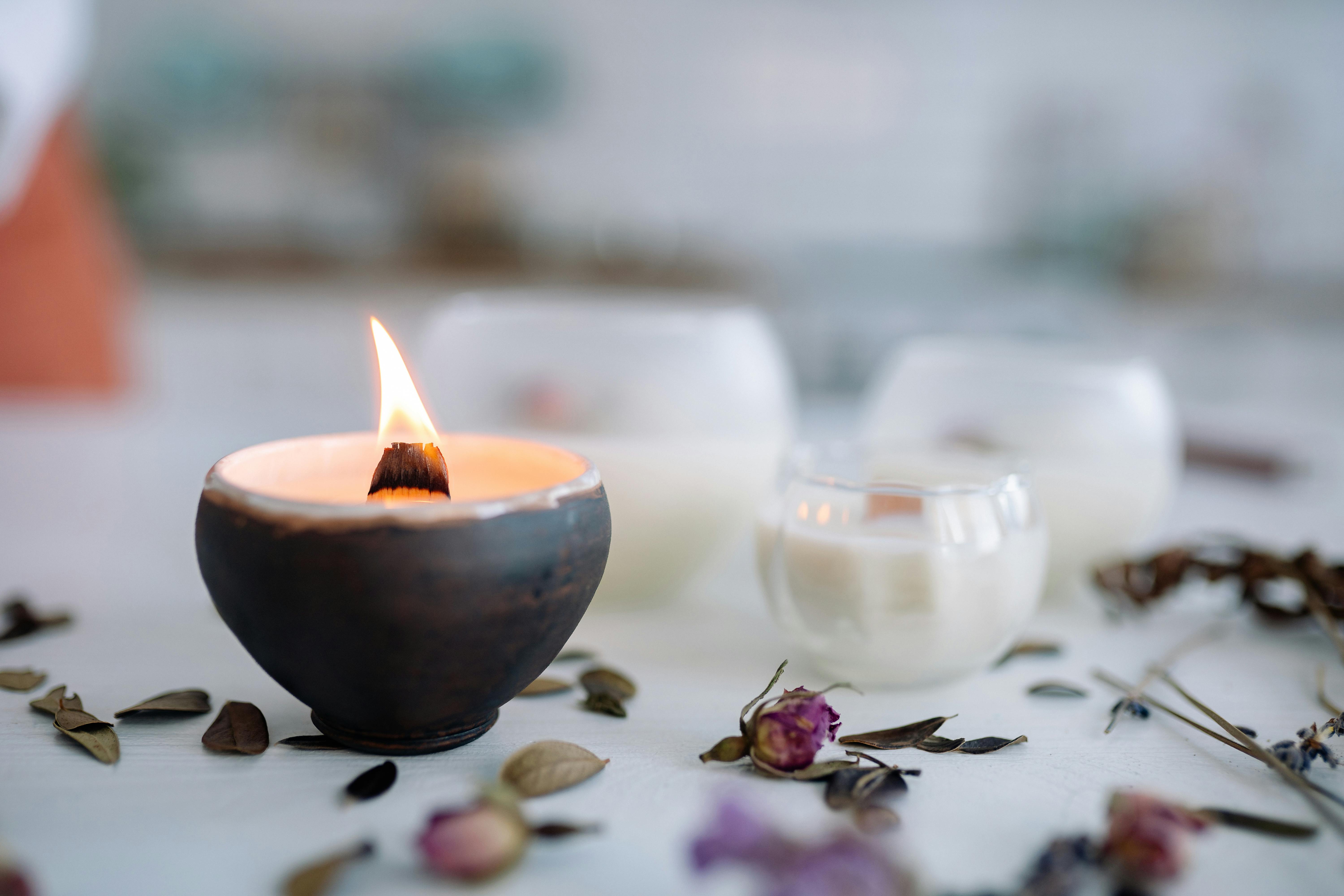 A burning candle on a ceramic container | Source: Pexels
