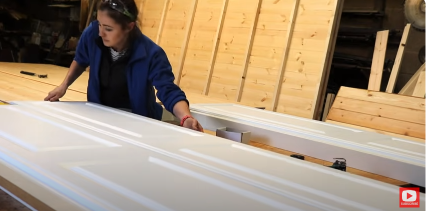 A woman attaching wardrobe doors to frames | Source: YouTube/@TheCarpentersDaughterUK