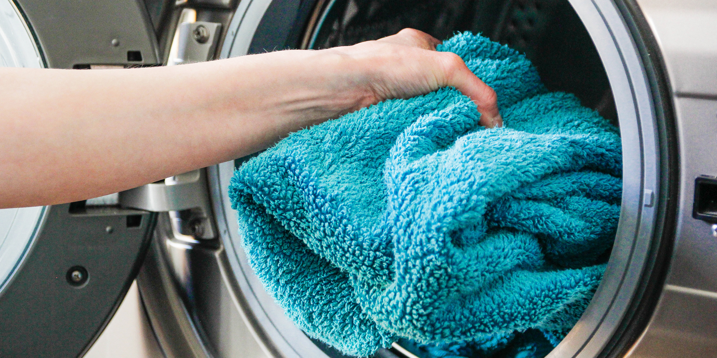 A person placing a towel into a dryer | Source: Getty Images