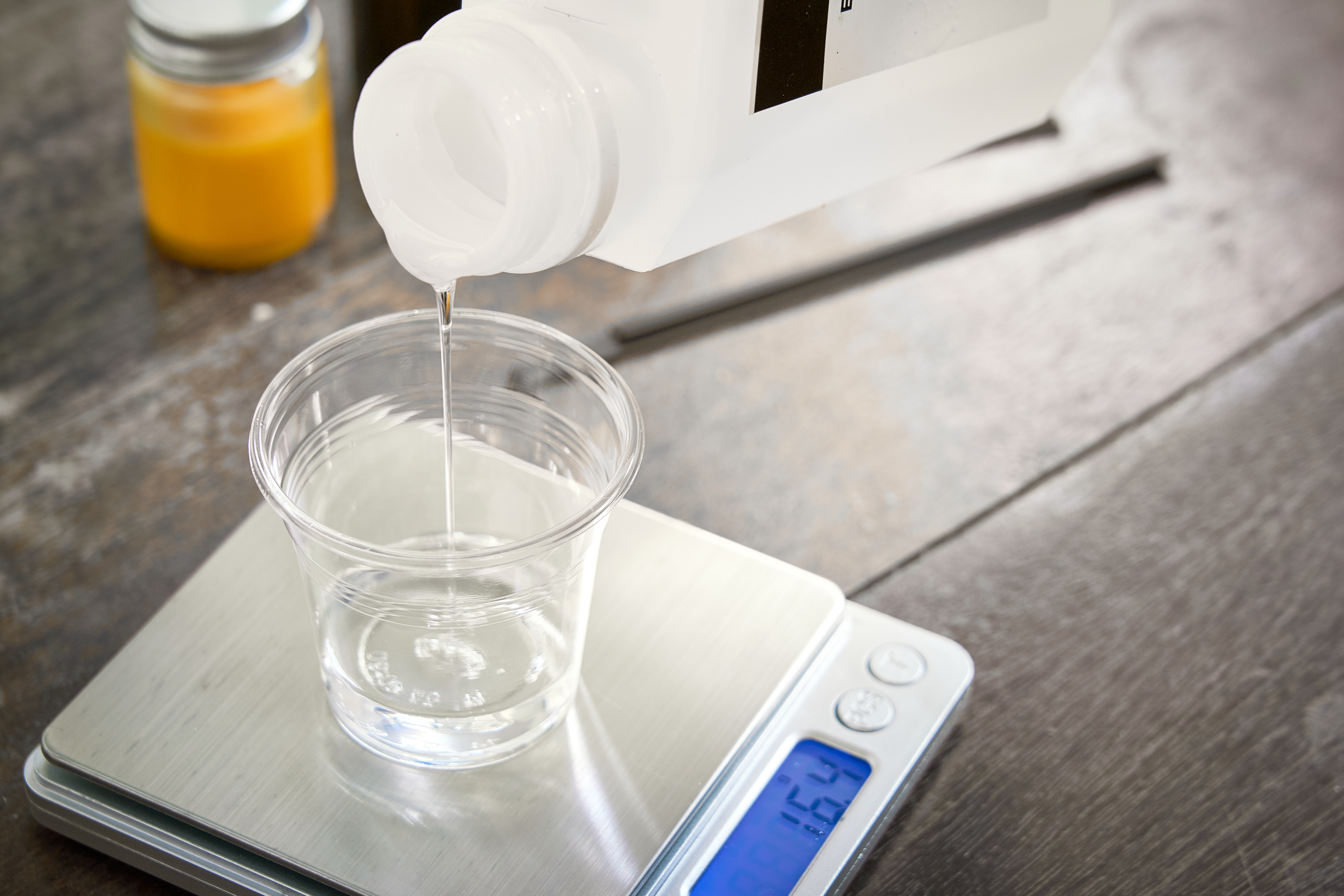 Pouring resin into a plastic cup on a food scale. | Source: Shutterstock
