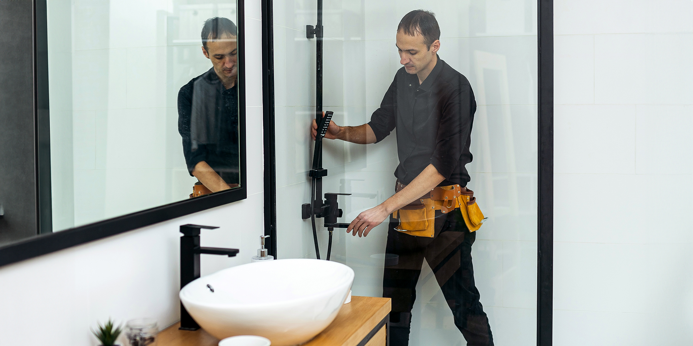 A man fixing a shower in a bathroom | Source: Shutterstock