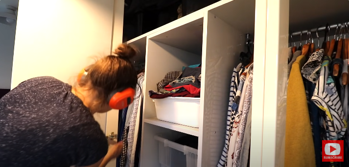 A person ensuring hinges are properly aligned with wardrobe door | Source: YouTube/@TheCarpentersDaughterUK