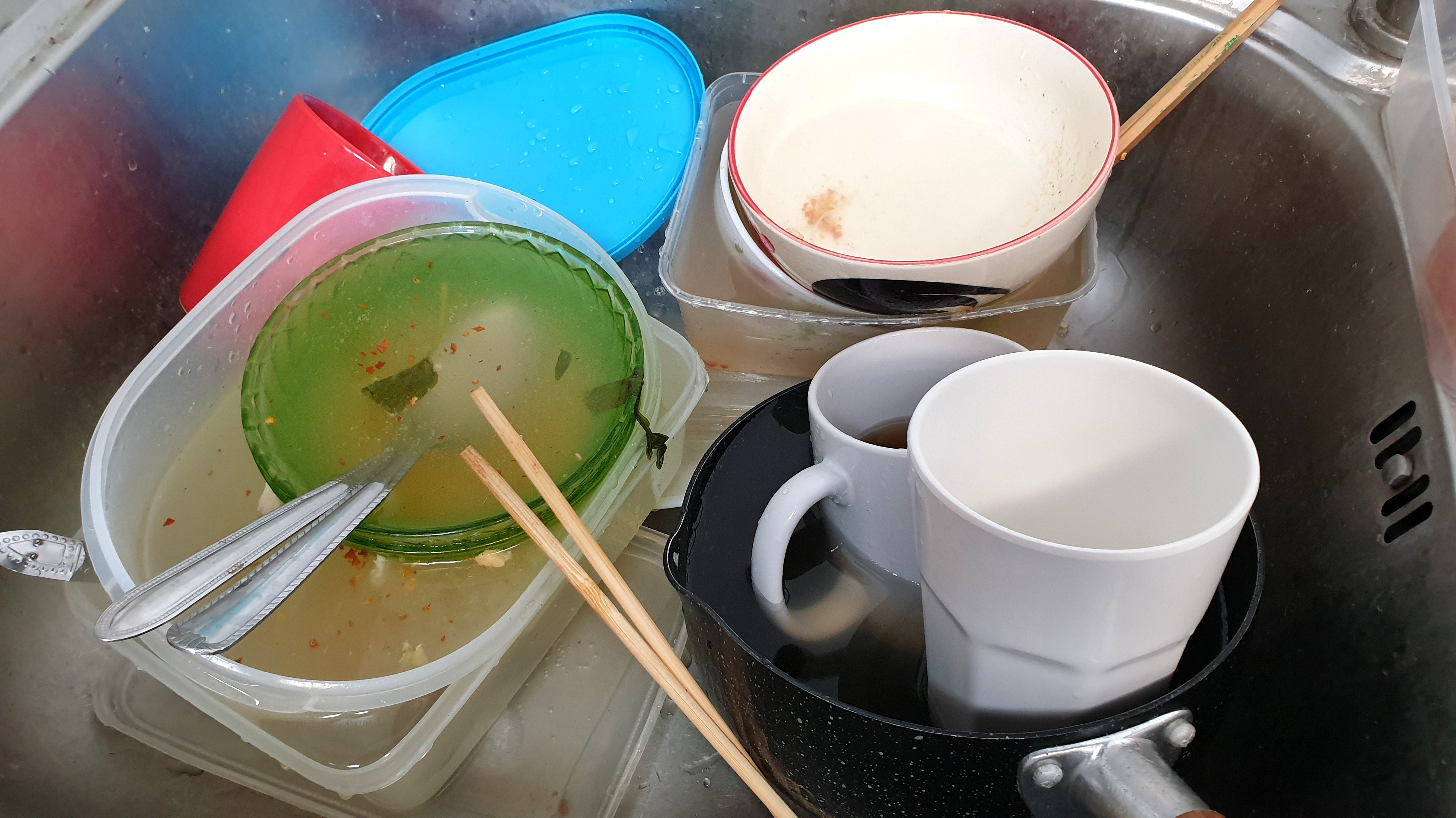 Dirty dishes and chopsticks in a kitchen sink | Source: Shutterstock