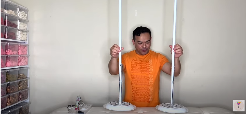 A man holding two DIY balloon column stands | Source: YouTube/fambamny/videos