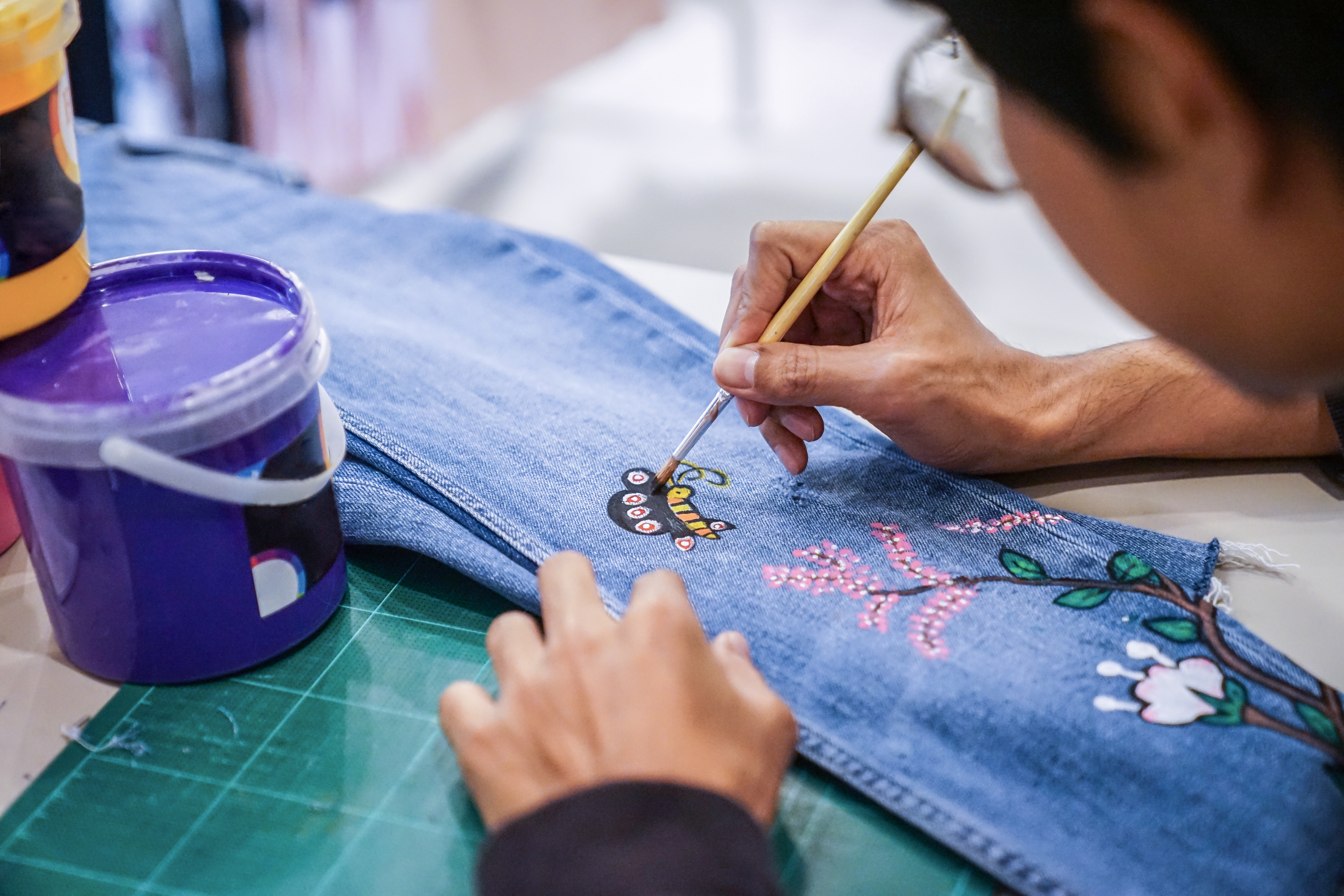 An artist painting a pair of jeans | Source: Shutter Stock
