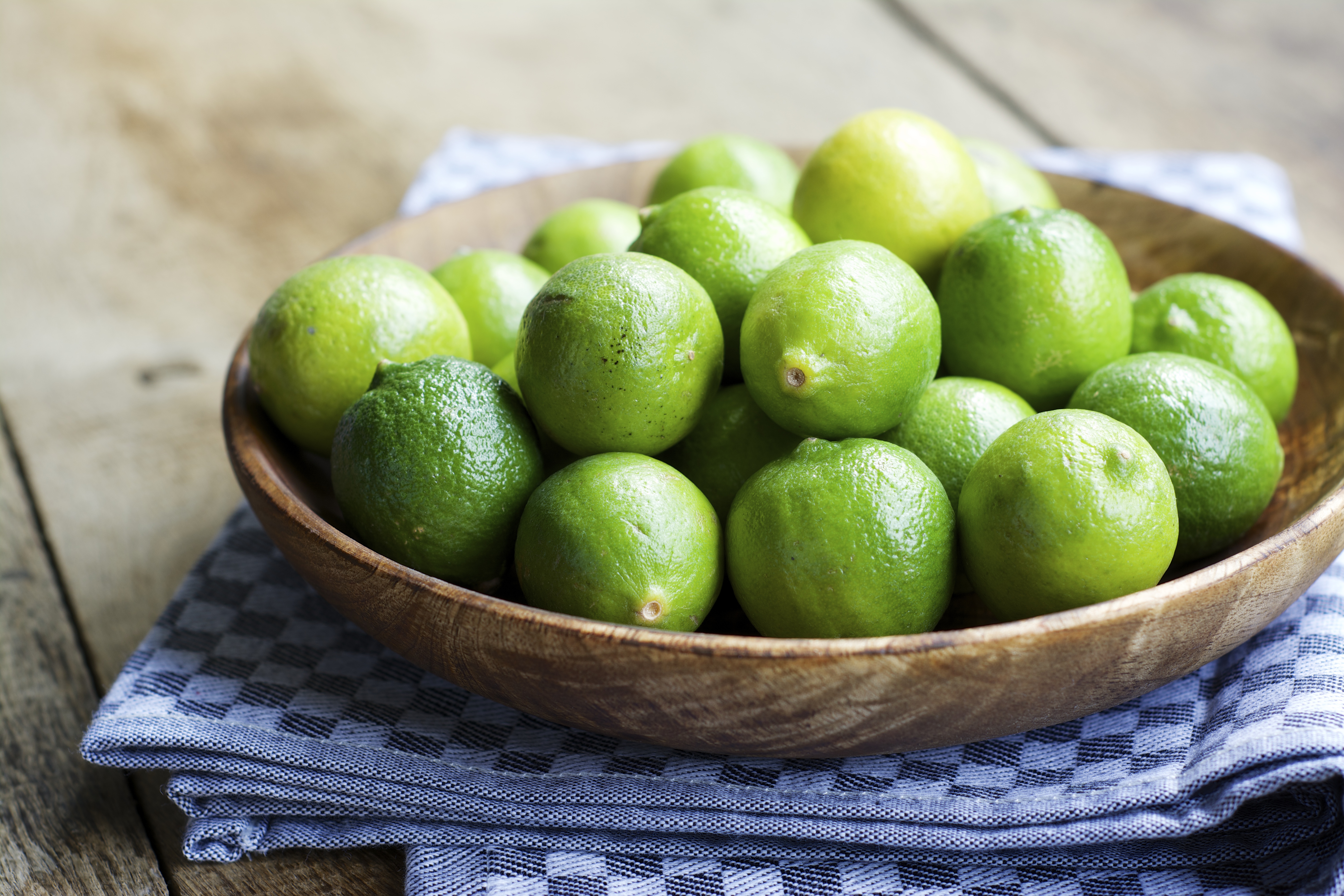 Limes in a wooden bowl. | Source: Getty Images