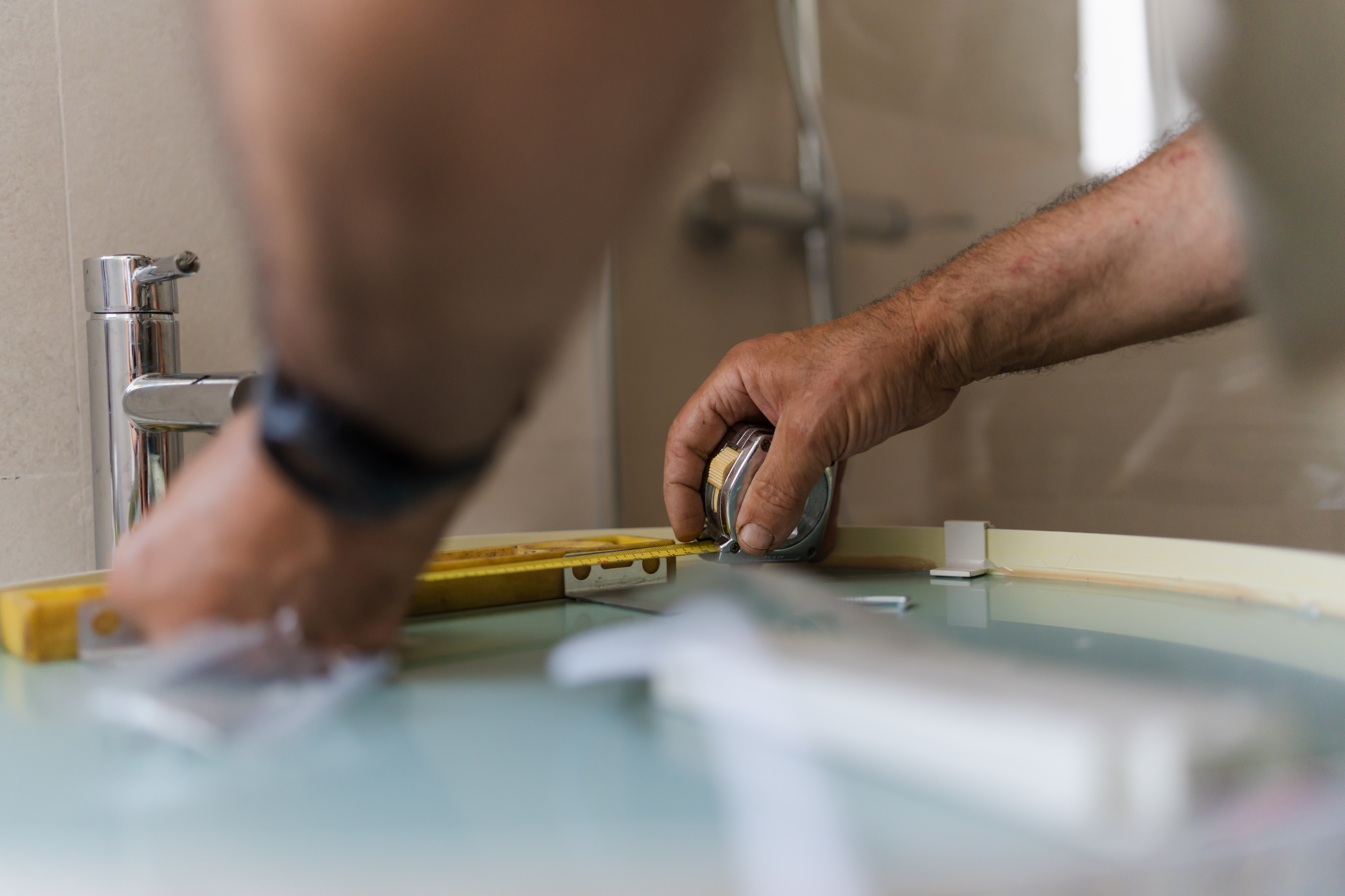 A man measuring a bathroom sink | Source: Getty Images