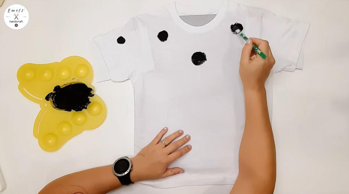 Apply dots of paint on the front of the shirt, then allow it to dry. | Source: YouTube.com/emelshandicraft