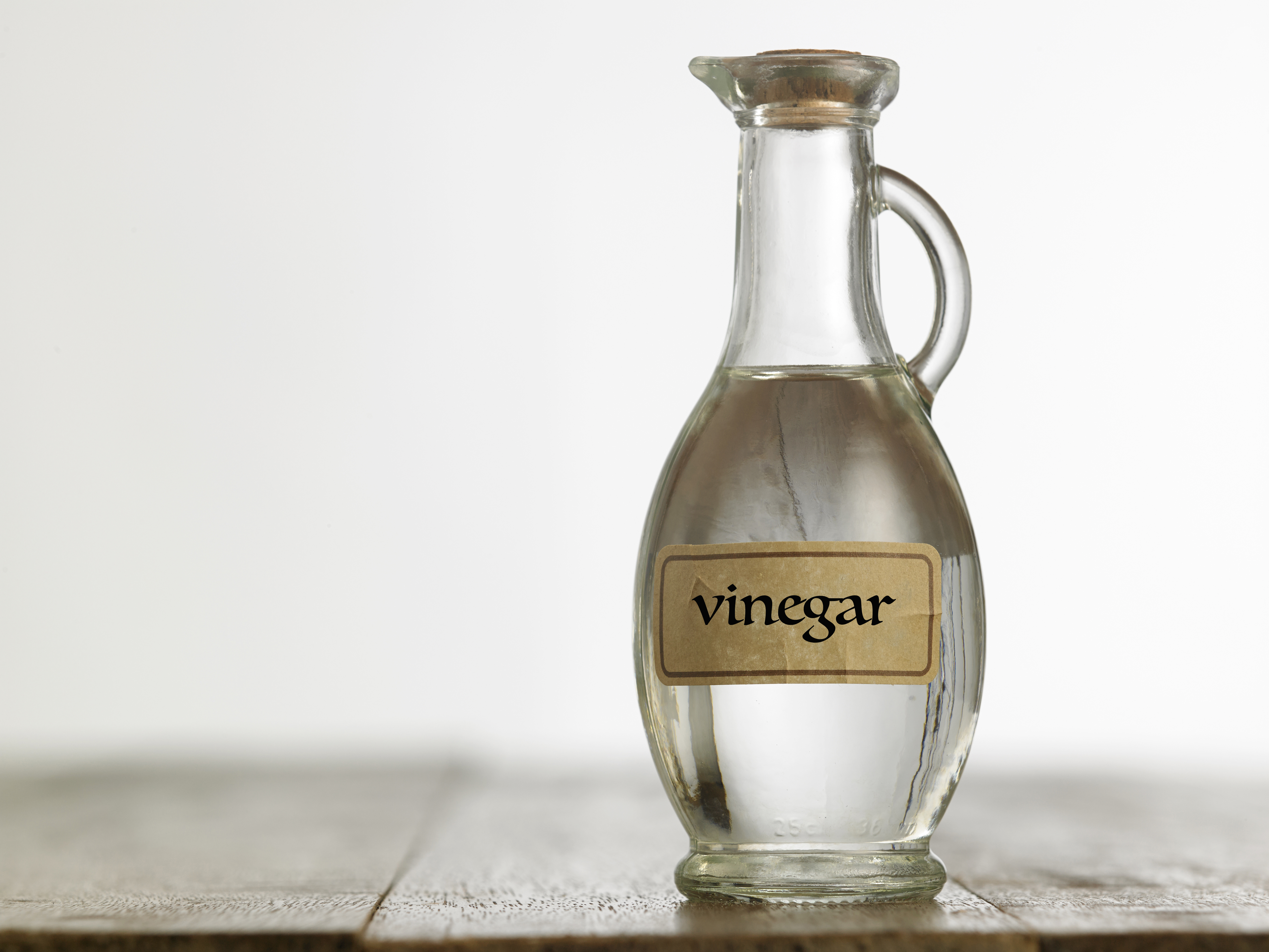 A jar of white vinegar on a wooden surface | Source: Pexels