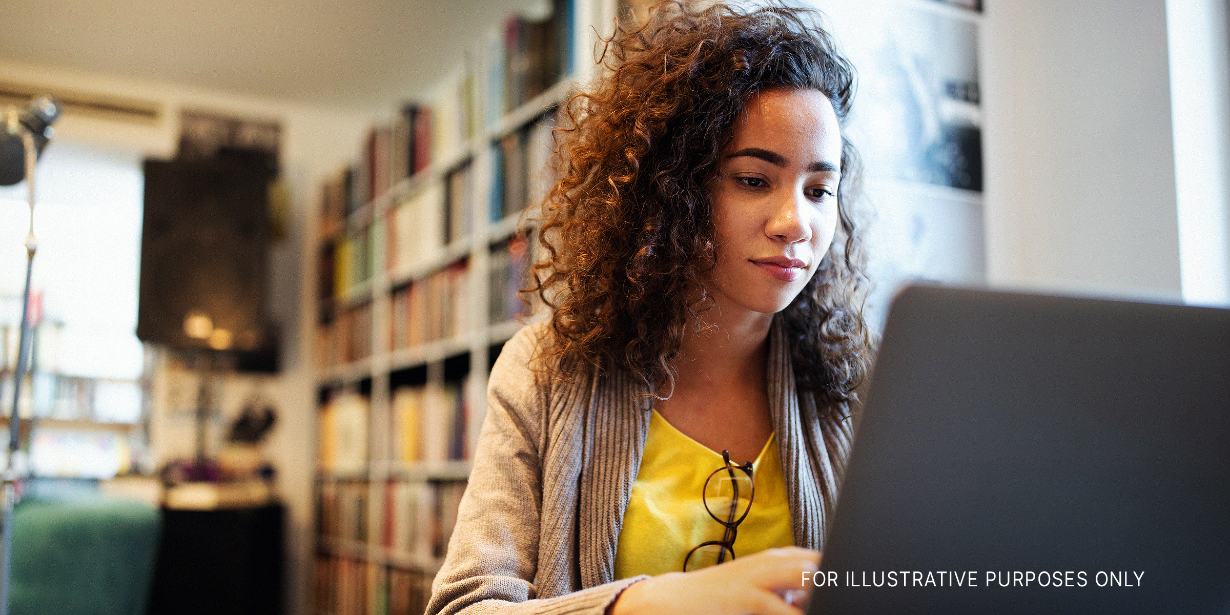 A college student doing research in a library | Source: Shutterstock