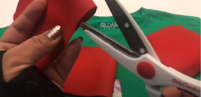 A person a red cloth using scissors | Source: YouTube/@craftingwithgaby
