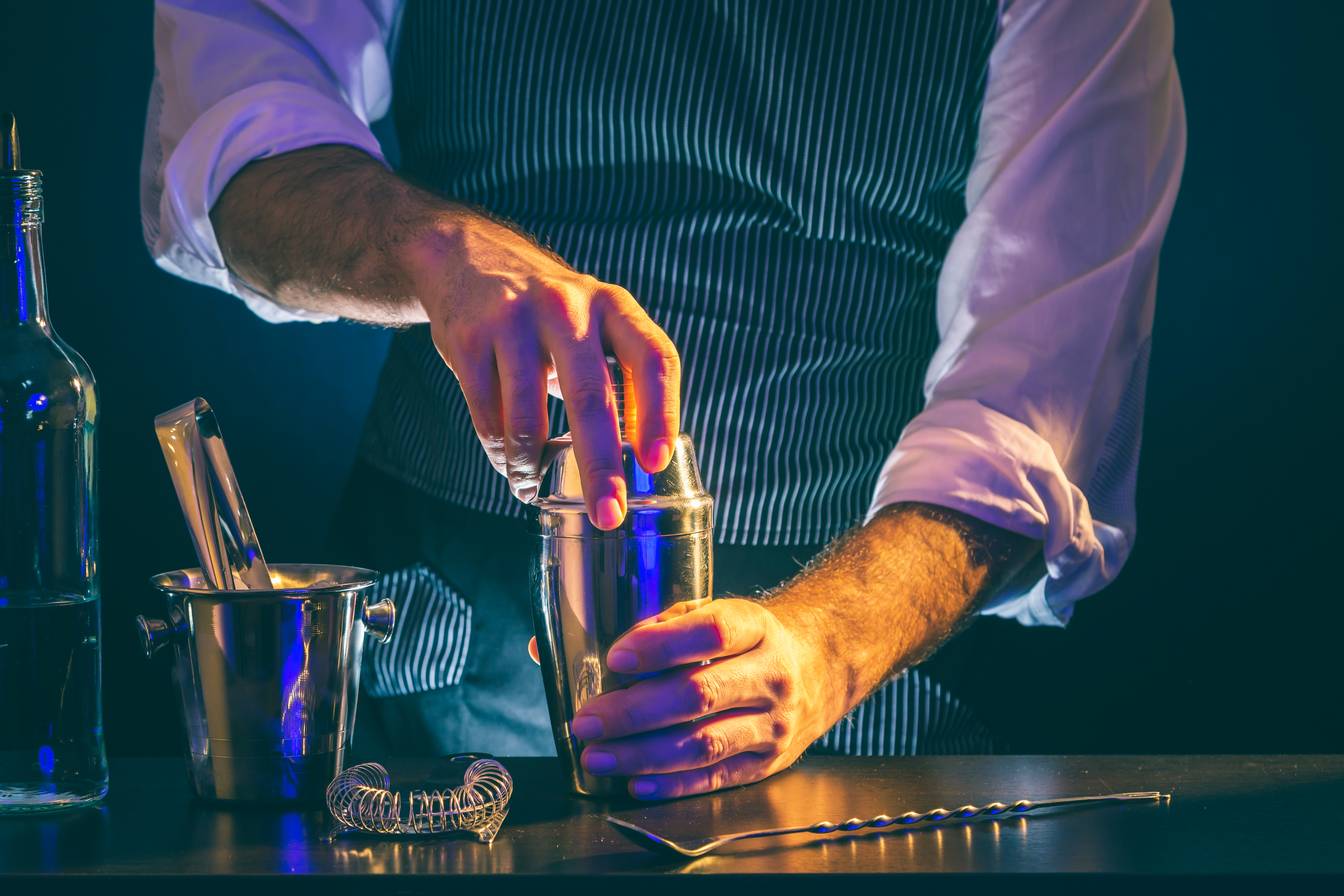 A bartender opening a cocktail shaker | Source: Shutterstock